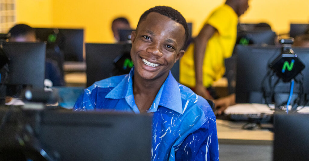 African youth on computer, smiling